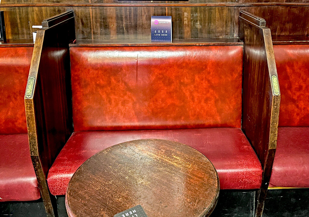 Portland Arms, Glasgow: Red upholstered benches with wooden dividers with match strikers attached