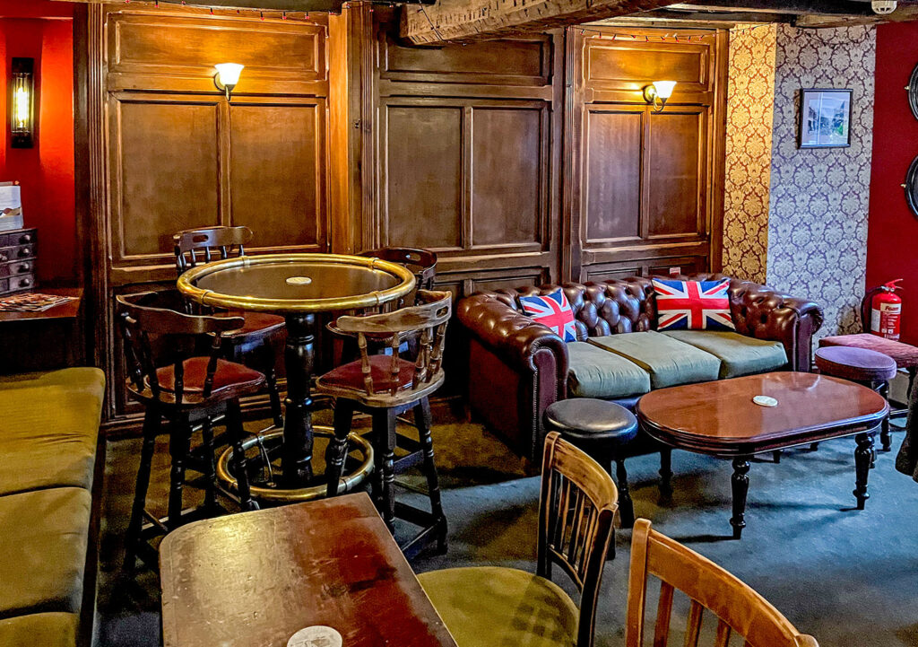 Angel, Stockport: Room with wood panelling, sofa, tables and chairs