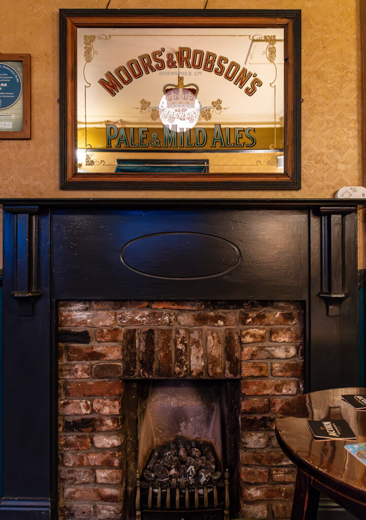 Golden Ball, York: Fireplace in Public Bar with 'Moors & Robsons' mirror above