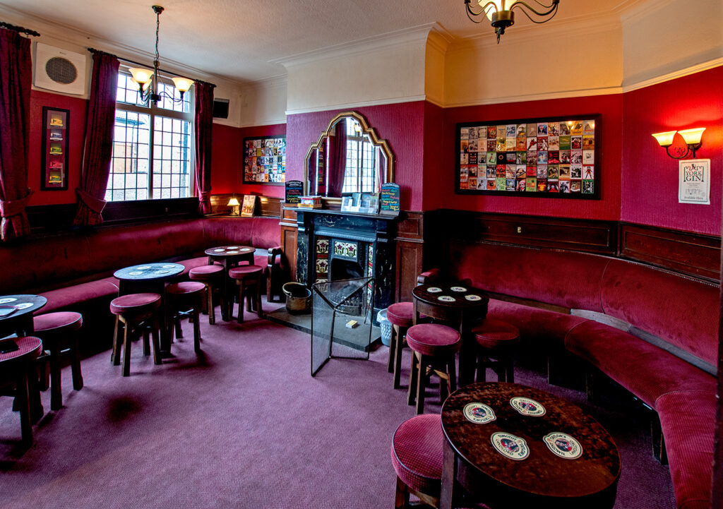 Swan, York: Smoke Room with red upholstered bench seating and stools