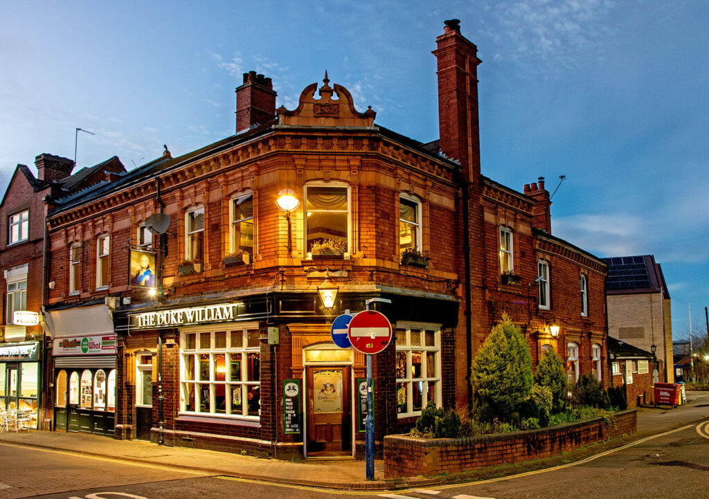 Duke William, Stourbridge: Illuminated red brick exterior at dusk