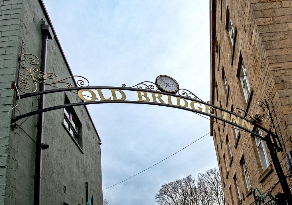 Kirkstall Bridge Inn, Leeds: Metal pub sign spanning entrance to courtyard.