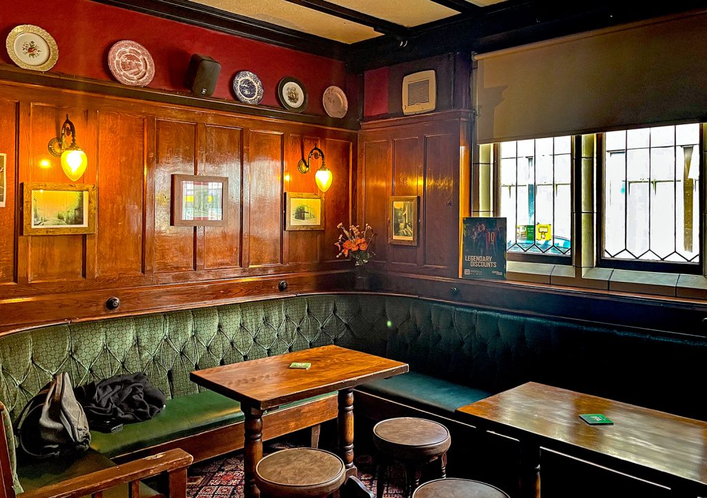 Templar, Leeds: Rear lounge with wood panelled walls and green upholstered bench seating