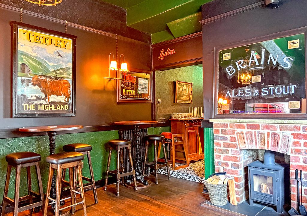 Highland Laddie, Leeds: Dining room with stove in fireplace, old inn sign and brewery mirror.