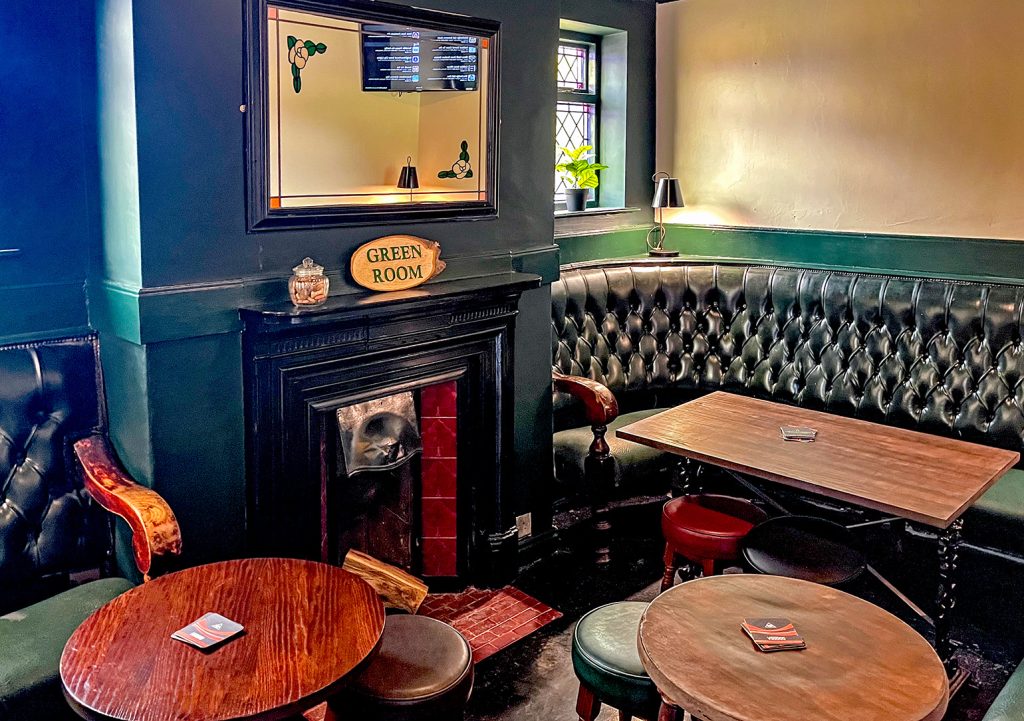 Crown, Stockport: Green Room with green upholstered seating, and fireplace with mirror above