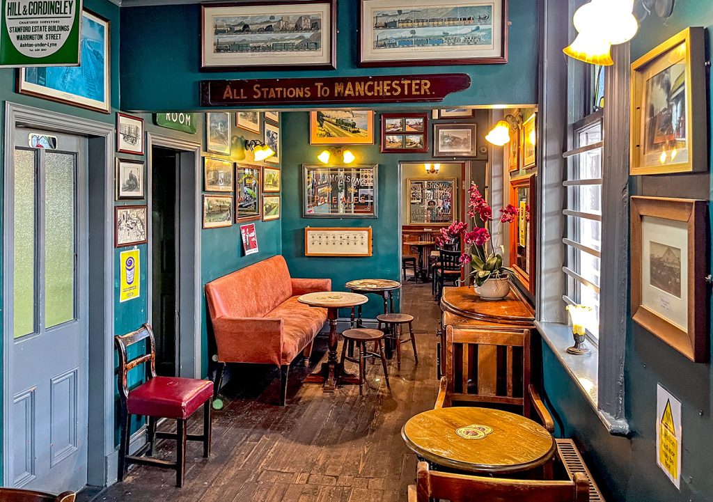 Station Buffet, Stalybridge: Passage with seating and railway images on wall.