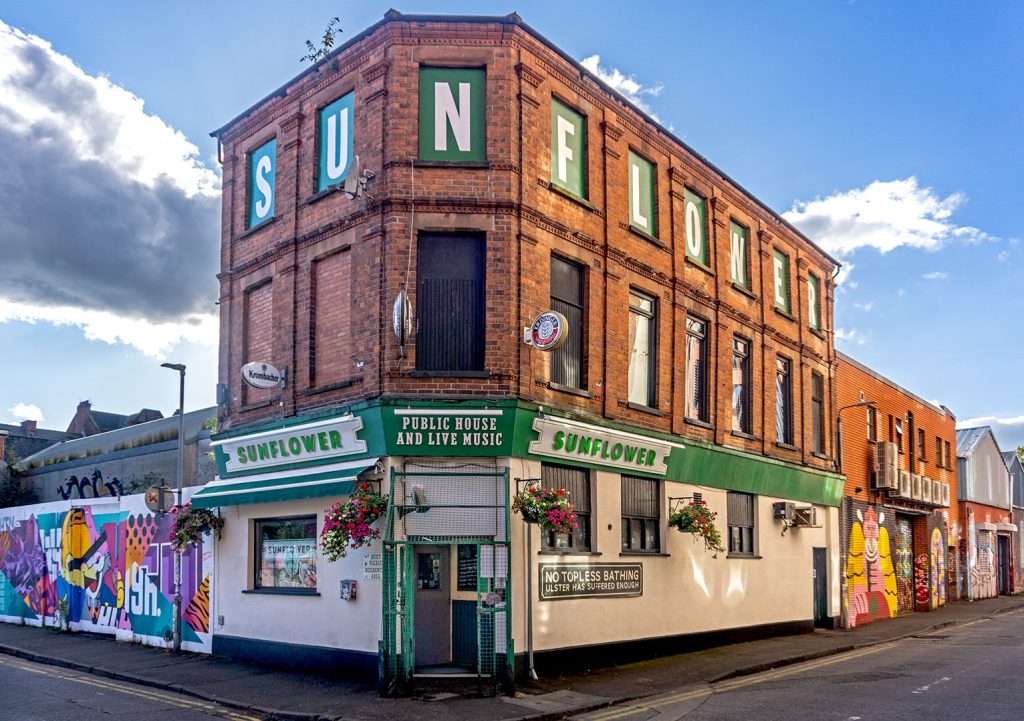 Sunflower, Belfast: Full exterior in daylight, a red brick corner pub with cream and green painted ground floor