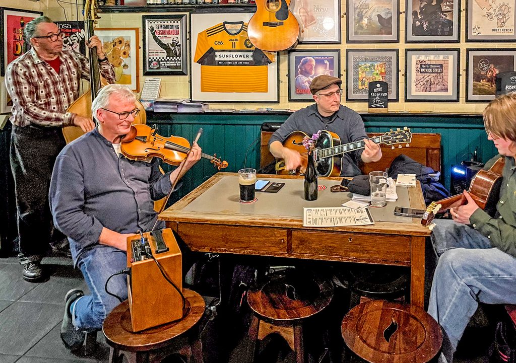 Sunflower, Belfast: The 4 members of the Manouche gypsy swing band playing double bass, violin, and 2 guitars.
