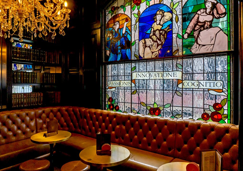 Bankers Cat, Leeds: Corner with stained glass and maroon upholstered bench seating