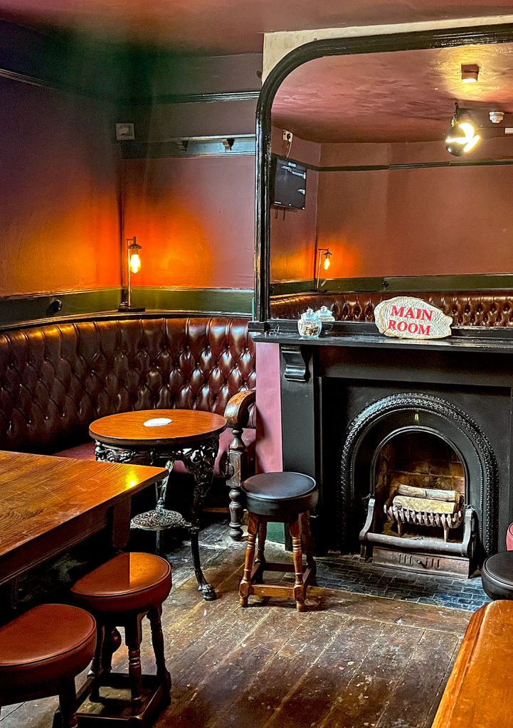 Crown, Stockport: Main Room with maroon seating, fireplace and large mirror