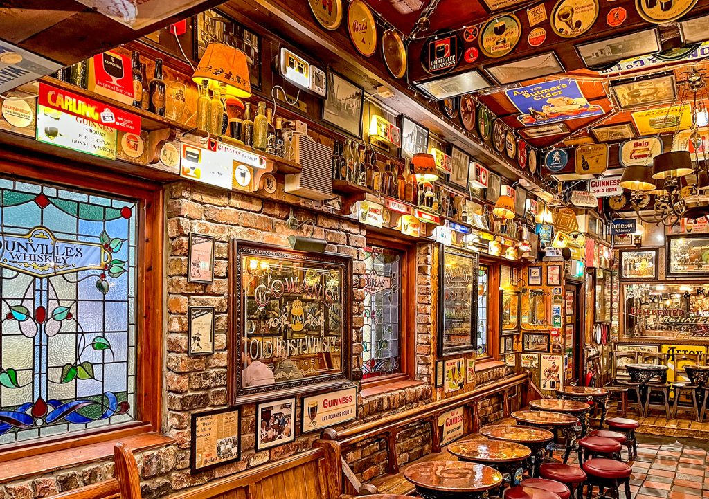 Duke of York, Belfast: Room with stained glass windows mirror and multiple signs promoting whiskies