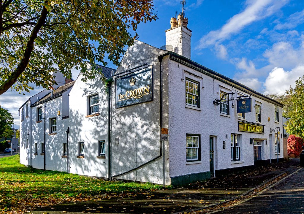 White painted exterior of the Crown with blue signage