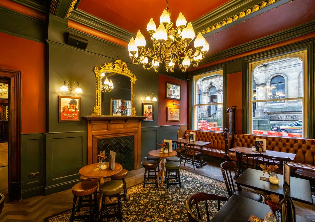 Victoria Hotel, Leeds: Front left room with chandelier, wooden fireplace and red upholstered seating