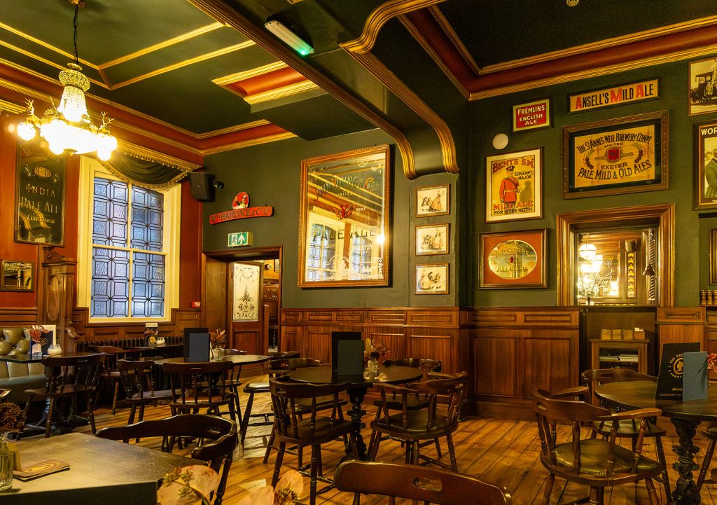 Victoria Hotel, Leeds: Rear left bar with tables & chairs, wooden floor and brewery mirrors and posters on wall