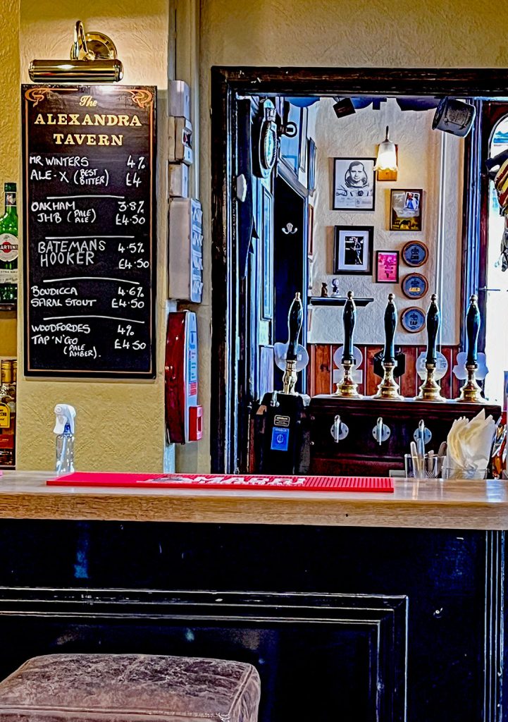 Alexandra, Norwich: Bar counter in back room with blackboard menu and view into front room.