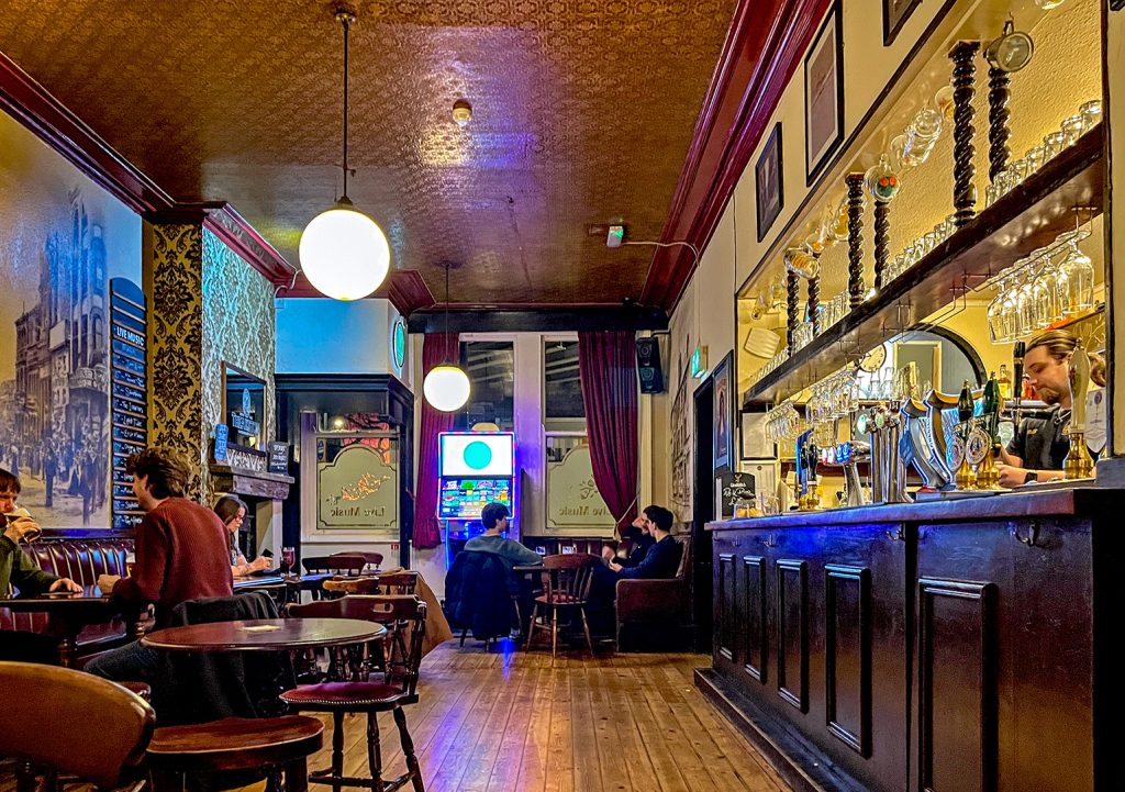 Duck and Drake, Leeds: Main bar with counter on right and customers seated around edge.