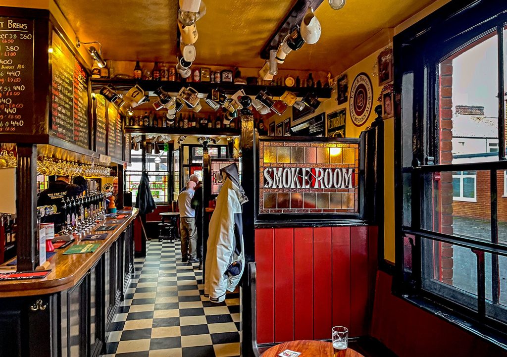 Fat Cat, Norwich: Main room with bar counter on left and wood and glass screens on right.