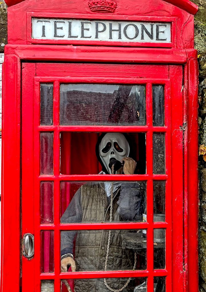 Birch Hall, Beck Hole: Old red telephone box with mannequin inside dressed as farmer with a skull face.