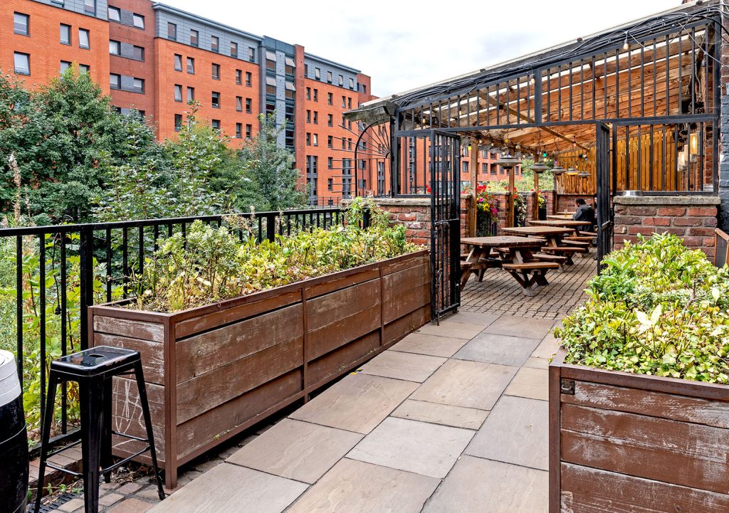 Riverside, Sheffield: Paved garden with planters and bench seating.